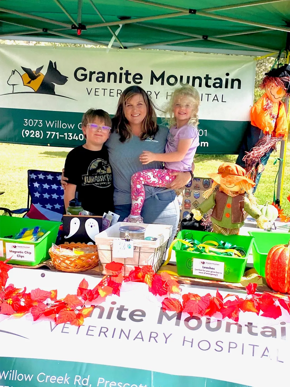 The Granite Mountain Veterinary Hospital booth at Woofstock, with the team banner and a table of fall treats and giveaways.